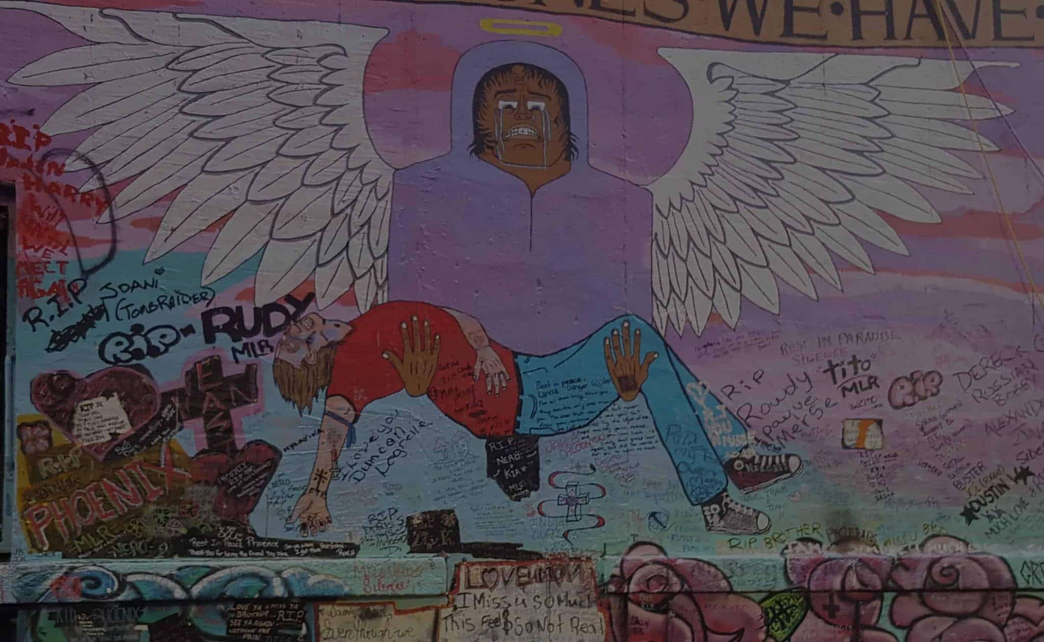 A painted mural of an angel lifting a deceased person up