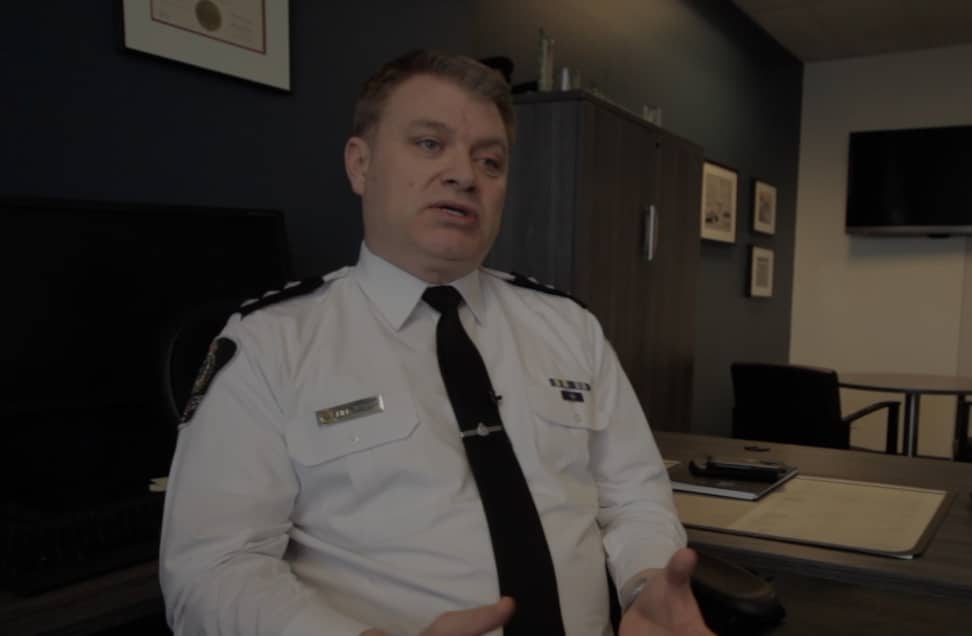 Bill Spearn, police officer, sitting at desk in office while speaking