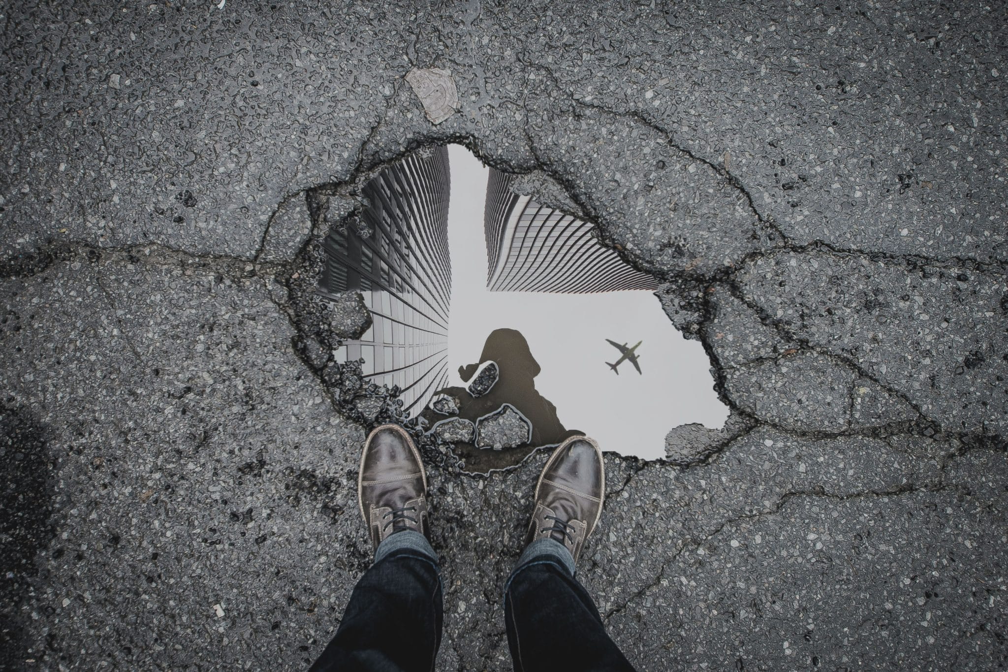 Person looks at their reflection in a puddle